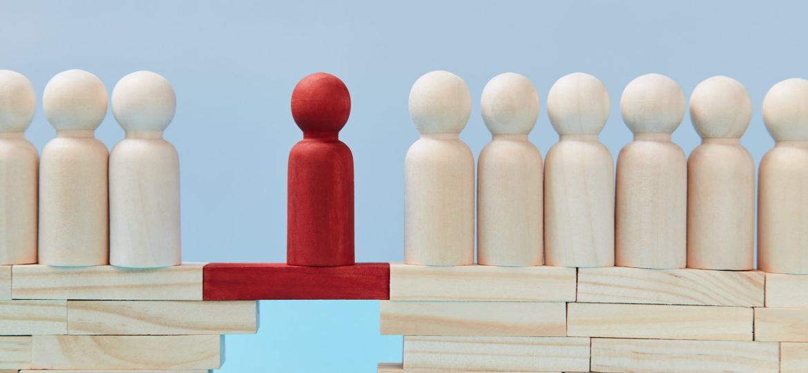 Not like everyone. Business risk. Leadership and superiority. People figures on bridge, one red person miniature on gap (Demo)