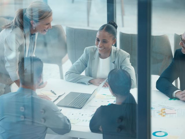 Leader, meeting and presentation with business people behind glass in a finance, data and growth discussion. Teamwork, collaboration and planning with executive team sharing goal, vision and idea